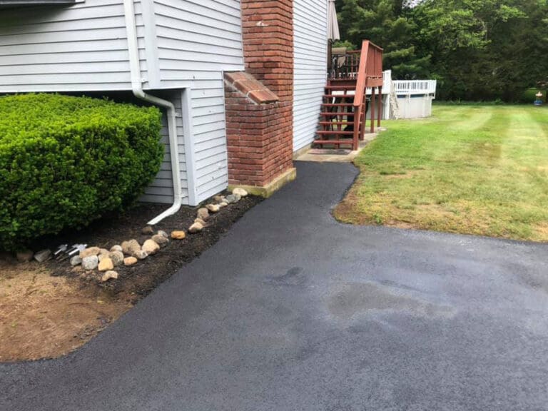 Driveway leading to a pathway on the side of the house with new asphalt